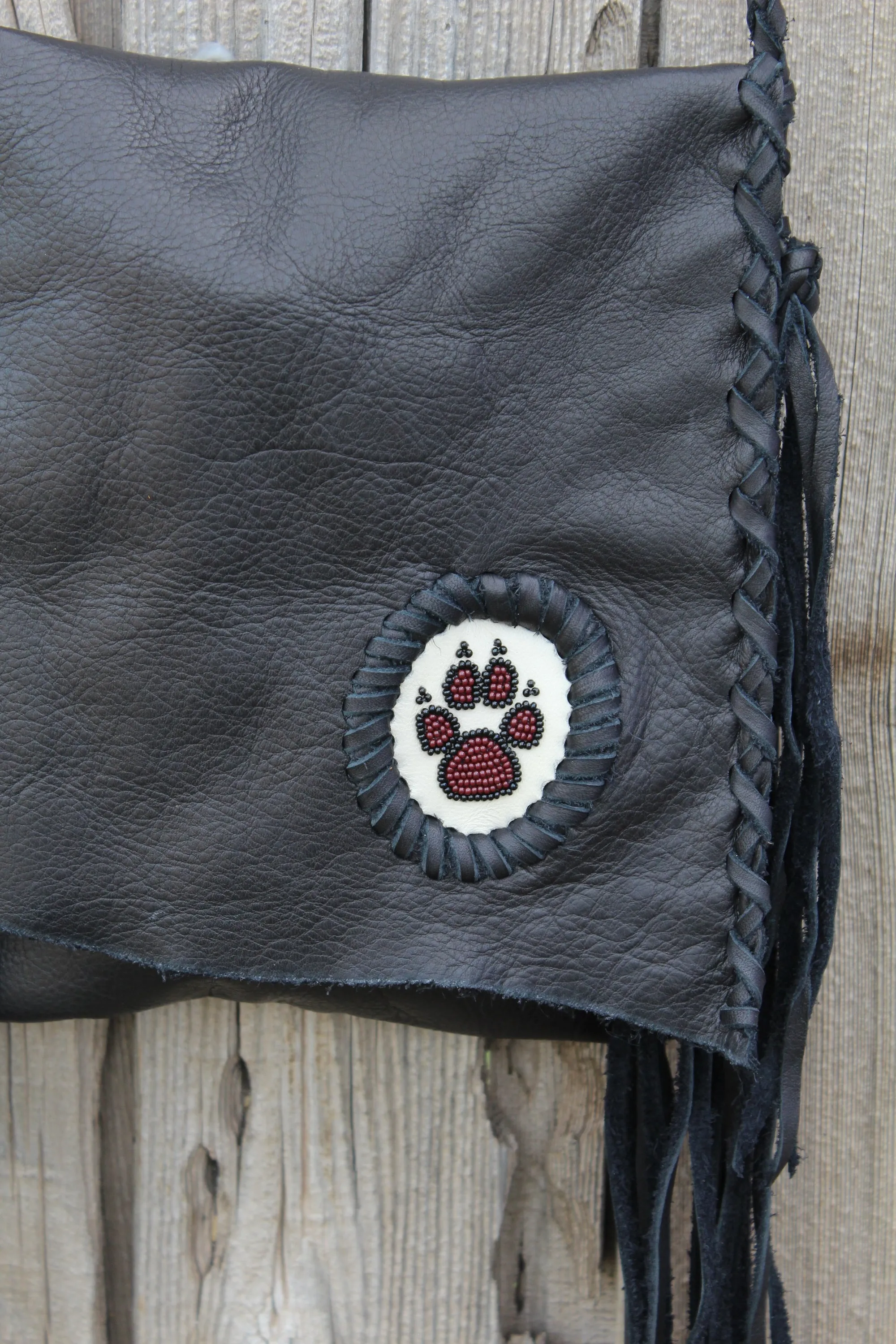 Black leather fringed handbag, beaded wolf paw design