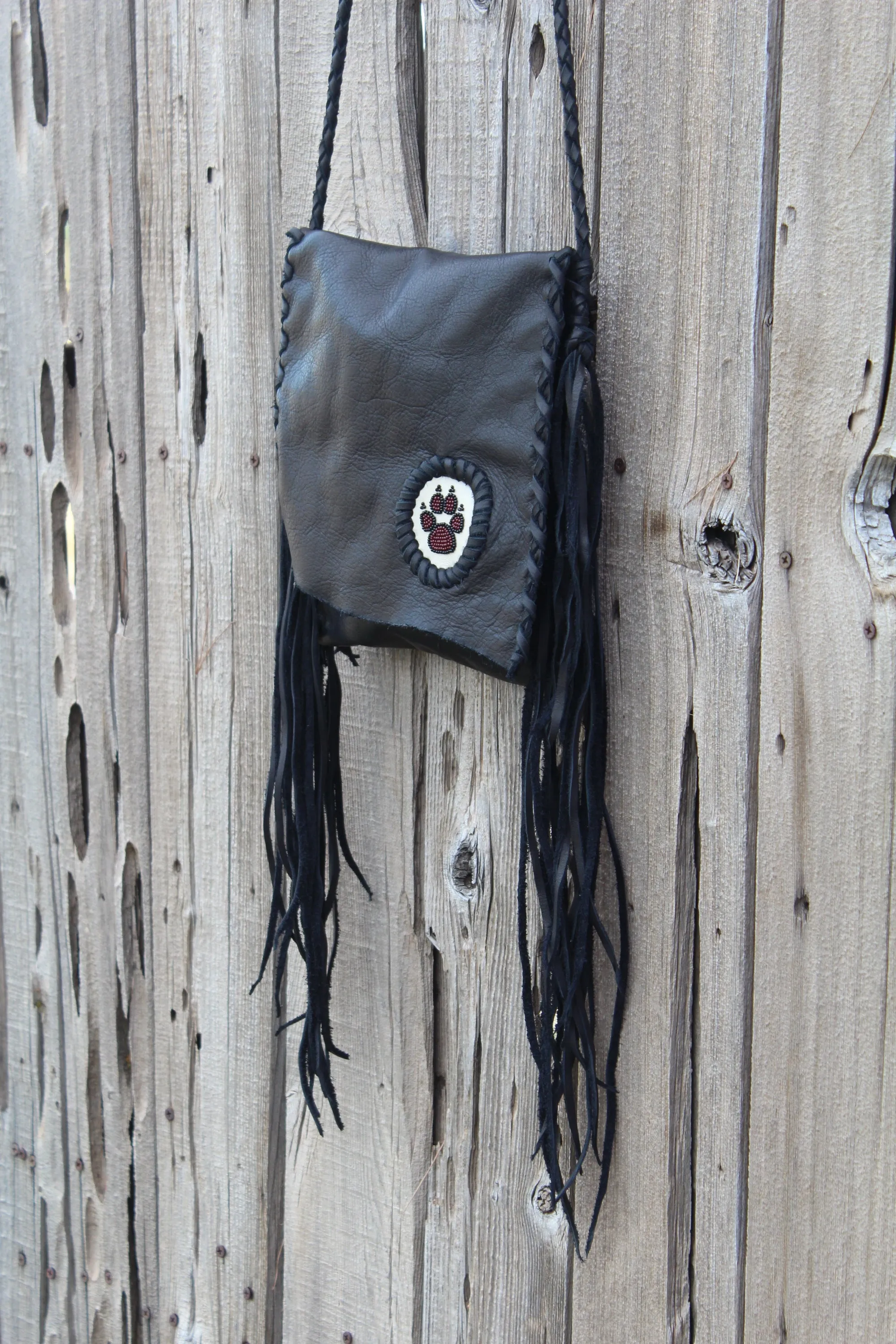 Black leather fringed handbag, beaded wolf paw design