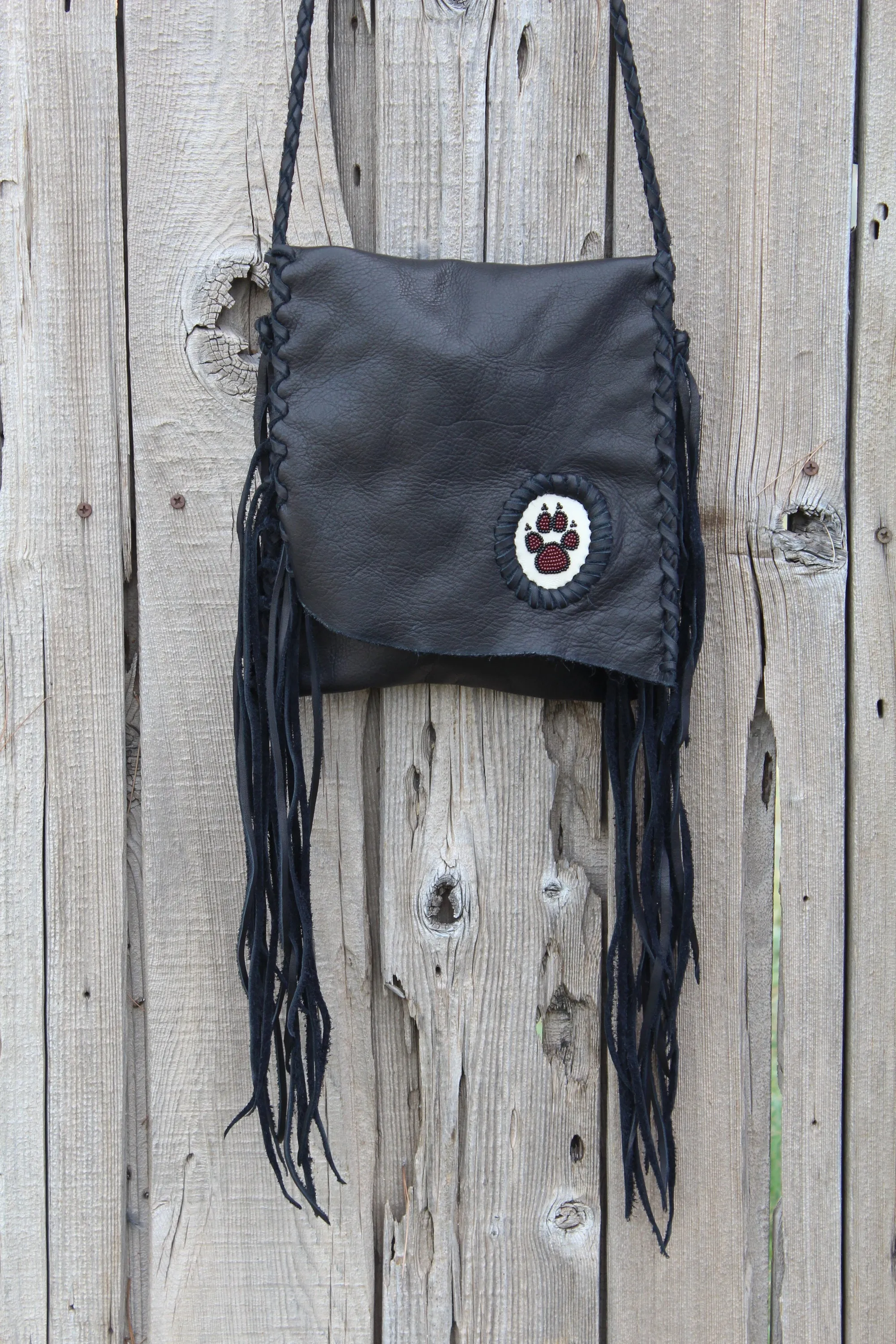 Black leather fringed handbag, beaded wolf paw design